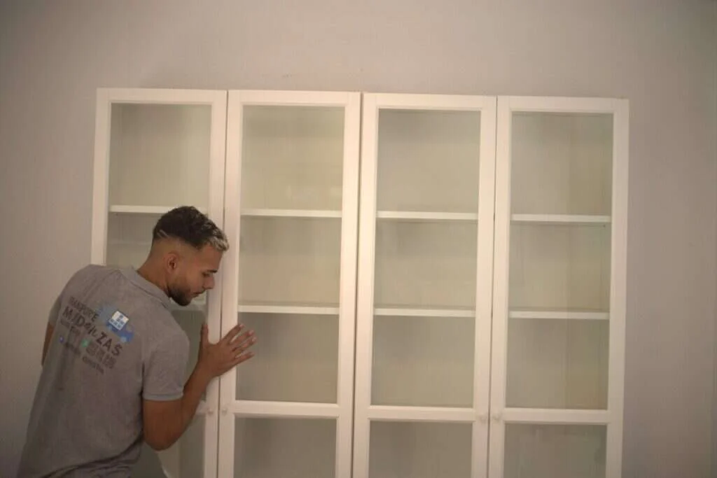 Operario montando una vitrina en el nuevo domicilio